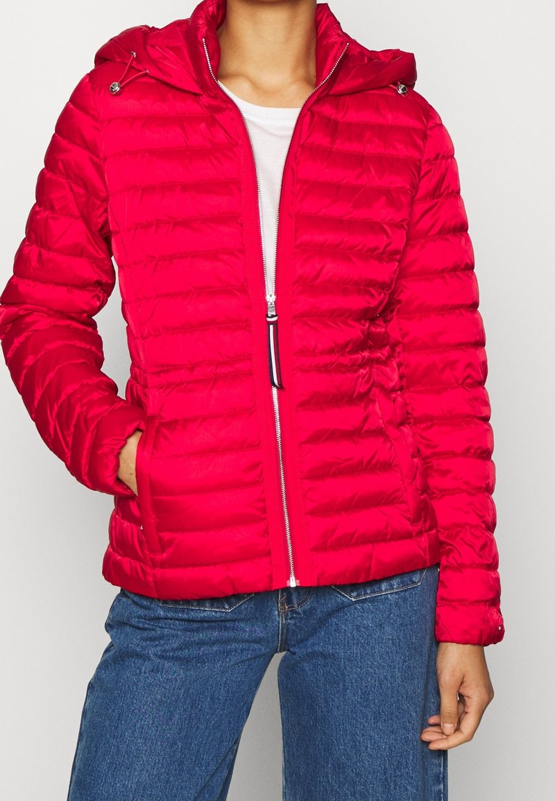 Rote, gepolsterte Jacke mit Kapuze, mit horizontaler Steppung, einem Frontreißverschluss und zwei Seitentaschen. Hergestellt aus glänzendem synthetischem Material.