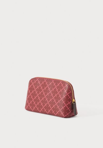 Punane tekstuuriga kott roosa ristikujulise mustriga; kuldse tõmblukuga ja pruun rõhutusega otsas. Kompaktne, kõver kujundus.