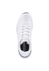Zapatilla deportiva blanca con una parte superior de malla texturizada, cordones, cuello acolchado y una suela de goma con franjas negras. Presenta la marca "Skechers".