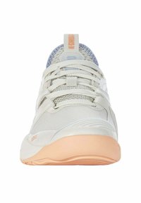 Zapatilla deportiva de color gris claro con parte superior de malla texturizada, cordones blancos y suela de melocotón suave. Presenta una lengüeta prominente en el talón y cortes laterales.