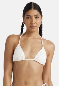 Top bikini triangolare bianco con stampa floreale, tessuto a coste testurizzato, sottili spalline regolabili a halter e dettaglio centrale arricciato.