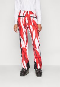 Schneehosen mit einem auffälligen roten und weißen Flammenmuster, aus einem strapazierfähigen Material mit Reißverschlusstaschen und einer schmal zulaufenden Passform.