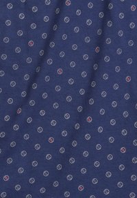 Granatowy materiał z powtarzającym się wzorem małych okrągłych kształtów, niektóre obramowane na biało z czerwonymi akcentami, przypominające guziki. Miękka tekstura.