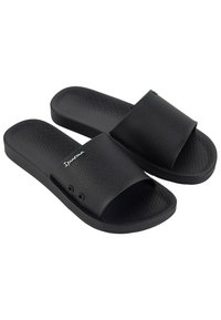 Chanclas negras con superficie texturizada. Correa superior ancha y diseño de punta abierta. Cuenta con un detalle de logo y pequeños agujeros de drenaje en la suela.