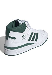 Hvide høje sneakers med grønne accenter og tre lodrette striber. Lavet af læder med en tekstureret overflade og en gummisål.