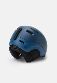 Blauer Skihelm mit Belüftungsöffnungen, verstellbarem Riemen und gepolstertem Innenleben. Matte Oberfläche mit schlankem Design und auffälligem Logodetail.