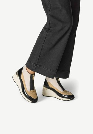 Pantofi cu toc wedges într-un design maro și negru, cu închidere cu fermoar, suprafață netedă și accente texturate. Așezați pe denim închis.