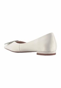 Ballerine beige clair avec une tige en cuir lisse, bout arrondi et un petit talon. Comprend un ornement décoratif à l'avant.