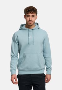 Ljusblå hoodie med dragsko, känguruficka, ribbade muddar och logga på bröstet. Mjuk tyg, avslappnad passform, minimalistisk design.
