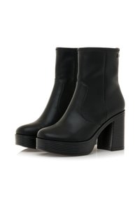 Botas de cuero negras hasta la mitad de la pantorrilla con tacones altos gruesos, punteras redondeadas, cremalleras laterales y suelas de plataforma texturizadas sobre un fondo blanco.