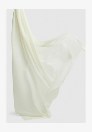 Gaismas, caurspīdīgs balts audums eleganti krīt, ar mīkstu tekstūru un saplēstām malām, radot plūstošu, smalku izskatu.