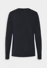 Pull noir uni à manches longues vu de dos avec poignets et ourlet côtelés, présentant une bordure discrète rouge et blanche sur les poignets.