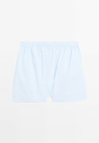 Shorts en coton bleu clair avec une taille élastique. Présente une coupe ample et des ouvertures latérales, conçus pour le confort et la liberté de mouvement.