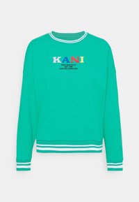Felpa blu petrolio con collo a girocollo, polsini e orlo a coste bianche, logo "KANI" multicolore e testo nero sul petto.