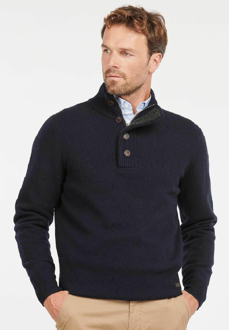 Marineblauer Strickpullover mit hohem Kragen, Drei-Knopf-Leiste und strukturiertem Gewebe. Einfaches Design ohne sichtbare Muster oder Hardware-Details.