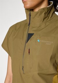Olive green, short-sleeved jacket with a high collar, front zipper, and black mesh accent. Features logo embroidery and contrasting stitching.