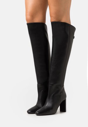 Schwarze kniehohe Stiefel aus glattem Leder, mit Blockabsatz und spitzem Zeh, einem nahtlosen Design und minimalen Akzenten.