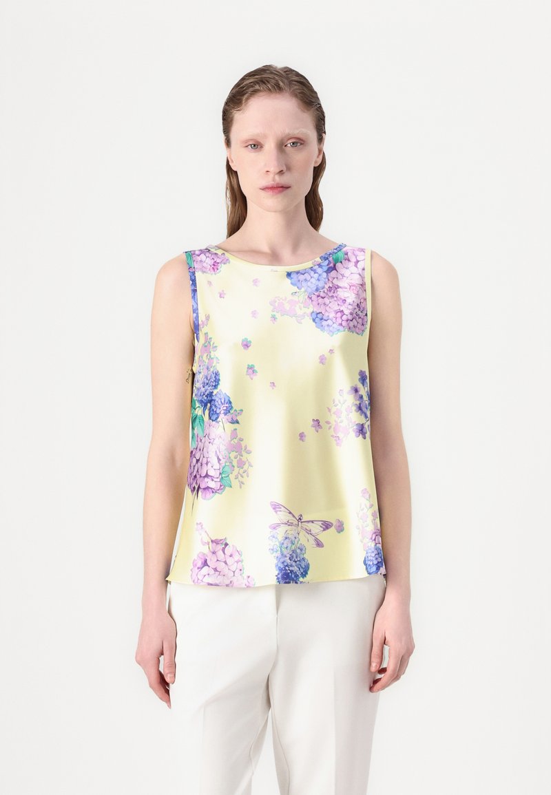 Top sin mangas en satén amarillo claro, con patrones florales morados y detalles en azul y mariposas. Textura suave y corte relajado.