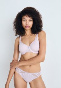 Lichtpaarse bh met kantaccenten bij de halslijn en schouderbandjes, gevormde cups en bijpassende slip met kantafwerking. Gladde textuur overal.