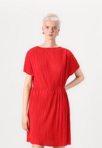 Vestido plissado vermelho com mangas curtas, cintura franzida e textura suave. Apresenta um cinto elástico e uma silhueta fluida.