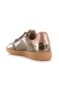 Metallisch zilveren sneaker met rose gouden hieltab, bruine veters en tan rubberen zool, in een hoek geplaatst om de achterkant en zijkant details te tonen.