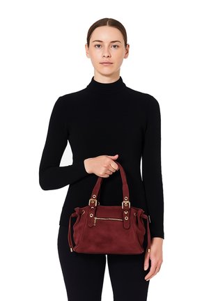 Burgundy suede handbag with dual top handles, a zippered front pocket, and gold-tone hardware. Soft texture, compact shape, and gathered detailing.