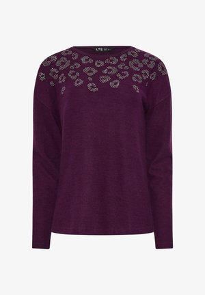 Paarse trui met lange mouwen en een verspreid patroon van zilveren studs in een luipaardprint op de borst en schouders.