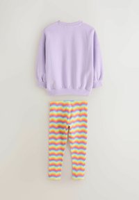 Svijetlofioletna majica s okruglim izrezom i naboranim rukavima iznad višebojnih tajica s valovitim prugama u ružičastoj, žutoj i plavoj boji.