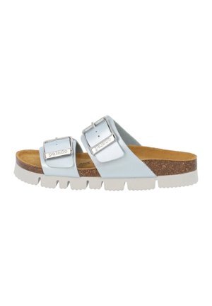 Light blue slide sandal with two adjustable metal buckles, cork footbed, and white rubber sole featuring textured tread.