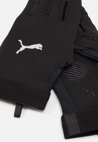 Mănuși negre cu un design ajustat, prezentând un material texturat și o manșetă netedă. Logo-ul alb Puma pe spate și linii grafice subtile.