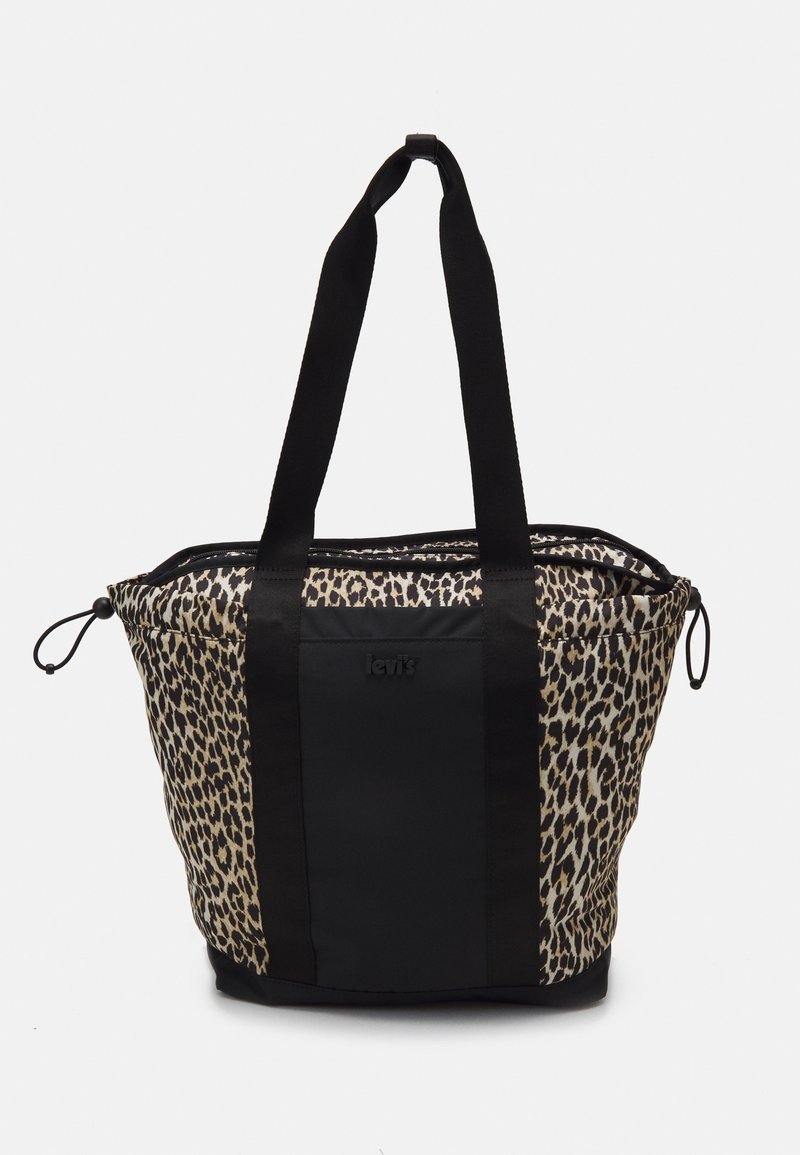 Sac fourre-tout Levi’s avec côtés imprimé léopard, panneau central noir, longues poignées noires et fermetures à cordon sur fond blanc.