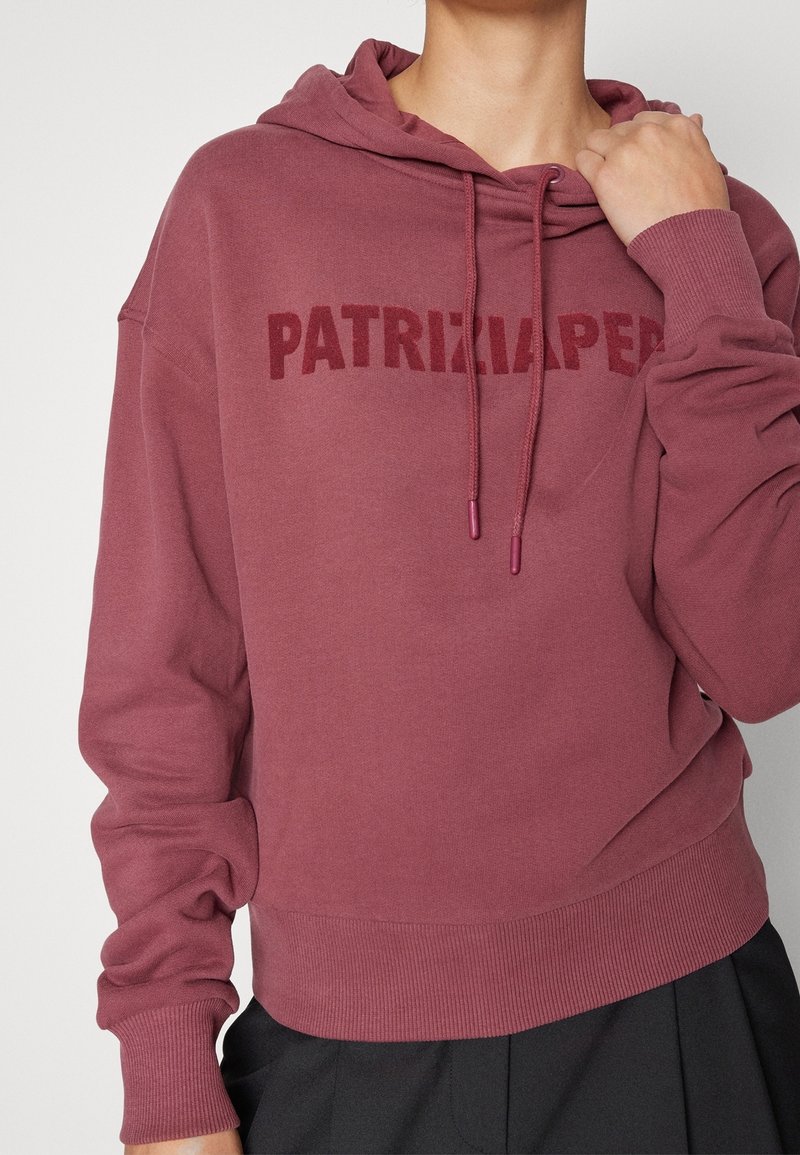 Felpa con cappuccio color bordeaux, con una stampa testurizzata di "PATRIZIA PEPE" sul petto, caratterizzata da polsini e orlo a costine. Tessuto morbido.