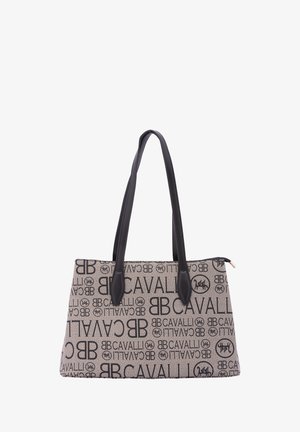Tote bag with a patterned canvas exterior featuring black text and logos, black leather handles, and a structured rectangular shape.