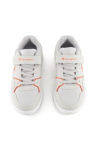 Graue Turnschuhe mit strukturiertem Stoff und Wildlederakzenten; ausgestattet mit orangefarbenen Details und einem Klettverschluss neben den Schnürsenkeln. Weiße Gummisohlen.