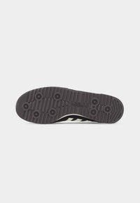 Μαύρη λαστιχένια σόλα παπουτσιού Adidas με κυκλικά μοτίβα πέδησης και ραβδωτή υφή, που εμφανίζει το λογότυπο Adidas και λεπτομέρεια με τρεις ρίγες στην άκρη.