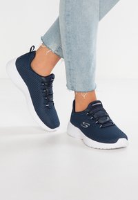 Sneakers in rete blu con lacci elastici, suola bianca e tomaia testurizzata. Design casual, adatti per diverse attività.
