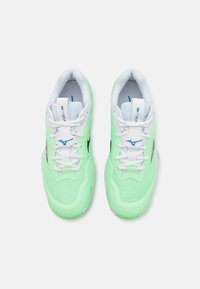 Baskets de sport vert clair avec des lacets et des accents blancs, présentant un dessus en maille texturée et un logo bleu sur le côté.