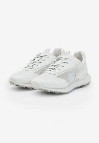 Zapatillas deportivas blancas con un exterior texturizado, paneles de malla y cordones negros en contraste. Incluyen un collar acolchado y una suela transparente.