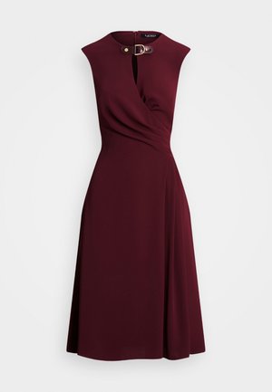 Vestido midi burdeos sin mangas con parte delantera cruzada, detalle plisado en la cintura y cierre con correa y hebilla dorada en el escote.