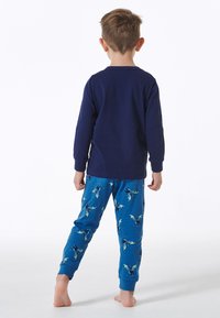 Langärmliges marineblaues Oberteil mit blauen Schlafanzughosen im Drachenmuster und Bündchen. Weicher Stoff, verspieltes Design und entspannter Schnitt.