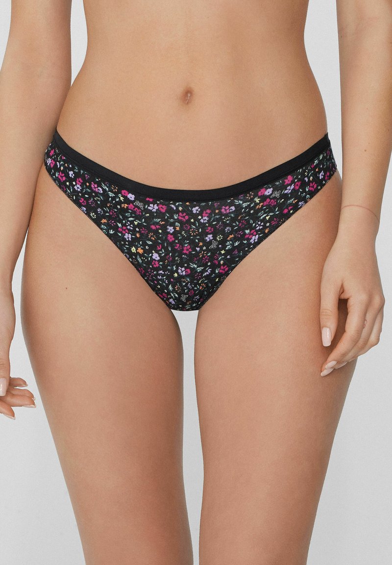 Culotte noire à motif floral avec un tissu stretch lisse, une taille élastique et des motifs de fleurs multicolores élaborés.