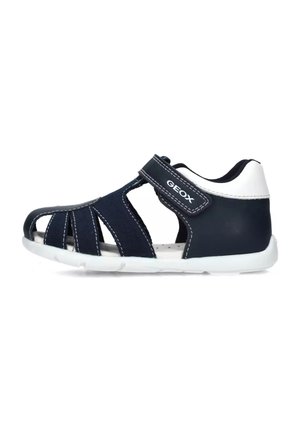 Sandalias de color azul marino con acentos blancos, hechas de material transpirable. Presentan un diseño abierto, tira de Velcro y una suela acolchada. Se aprecia la marca Geox.
