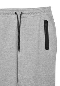 Hellgraue Jogginghose mit schwarzem Kordelzug und vertikalem schwarzem Reißverschlusstaschen auf der rechten Seite.