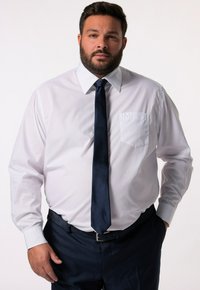 Weißes Hemd mit Knopfleiste und Tasche, kombiniert mit einer dunkelblauen Krawatte und Hose. Glatter Stoff mit langen Ärmeln und klassischem Kragen.