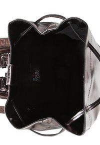 Metalen bronzen draagtas met een brede opening, een soepele textuur en een donkere voering van stof. Voorzien van korte handvatten en een merklabel aan de binnenkant.