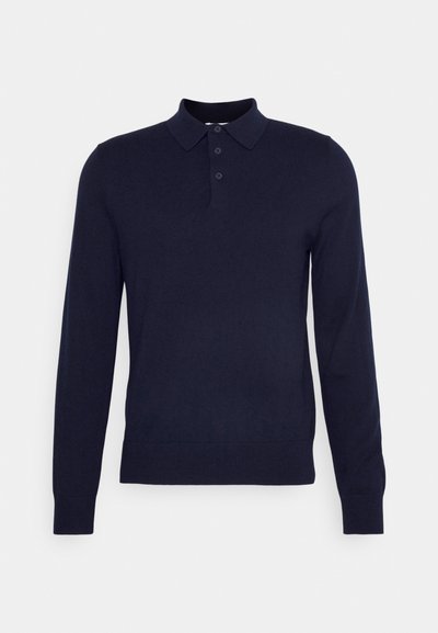 Marinblå långärmad polo skjorta tillverkad av ett slätt tyg. Har en klassisk krage, tre knappar på kragen och ribbade manschetter och fåll.