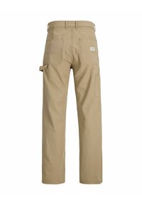 Pantalon de travail beige avec jambes droites, deux grandes poches arrière, une boucle latérale pour outils et une petite étiquette sur la poche arrière droite.