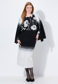 Outfit in bianco e nero composto da una blusa floreale, una gonna aderente a gradiente che va dal nero al bianco e collant neri con fiocchi.