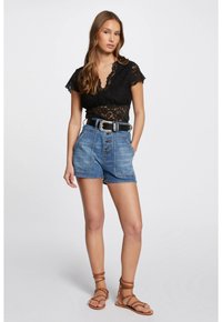 Top in pizzo nero con maniche corte, pantaloni cargo in denim blu a vita alta e sandali marroni con cinturini. Caratterizzato da chiusura a bottoni e dettagli con tasche.