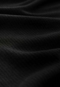 Čierna textúrovaná látka s jemným rebrovaným vzorom, ktorá vykazuje hladký, mäkký záves a jemný lesk pri rôznom osvetlení.